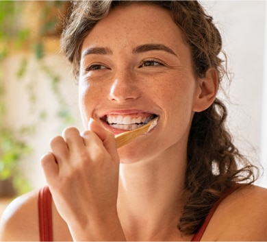 Young woman is brushing her teeth